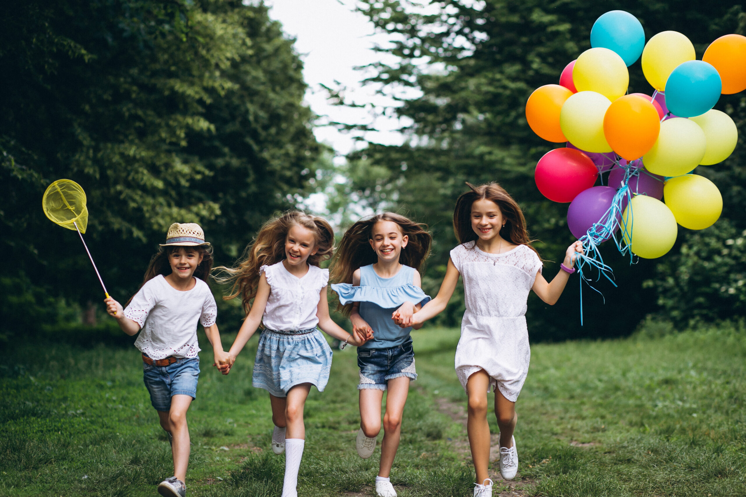 Little girls friends with balloons in forest